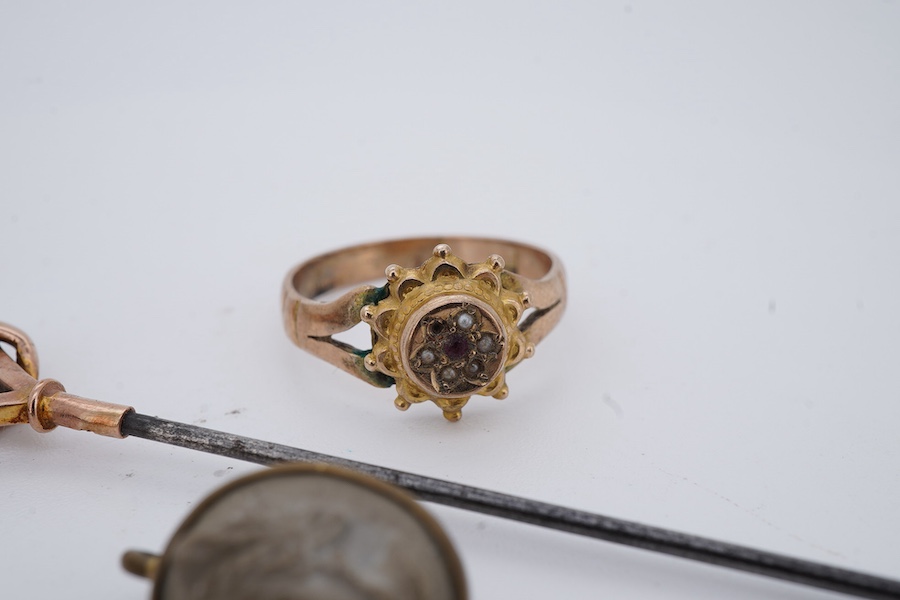 A collection of jewellery, comprising: a brooch, pair of earrings and a stick pin set with lava cameos; a stick pin capped with a geometric motif in gold, stamped 9CT; and a ring set with seed pearls and a garnet